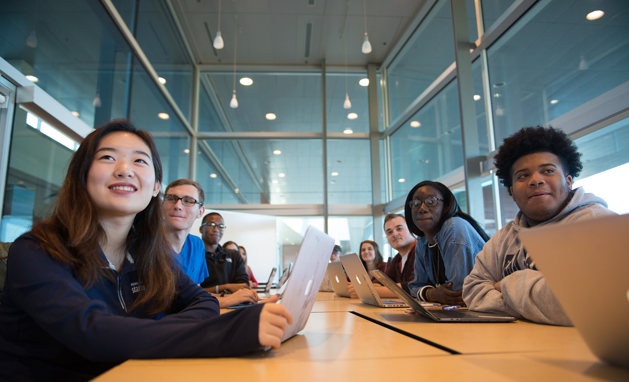 Students with laptops look ahead at a presentation