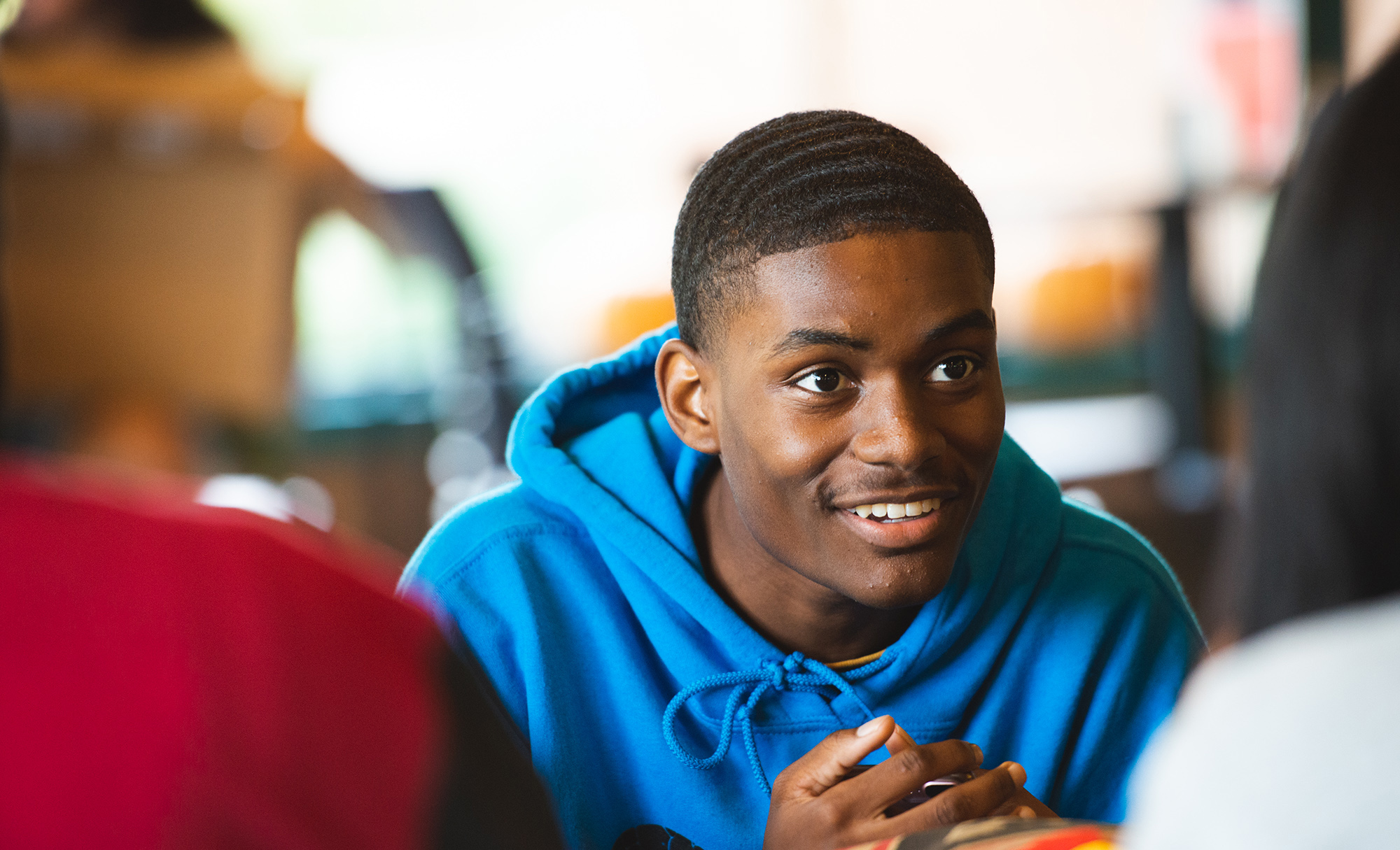 Smiling student enjoying a conversation with peers