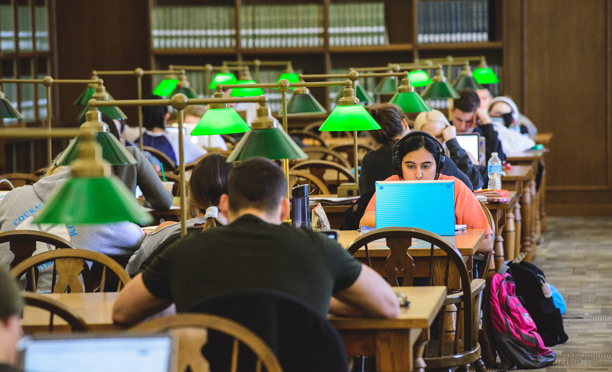 Students seated as tables and studying in the library