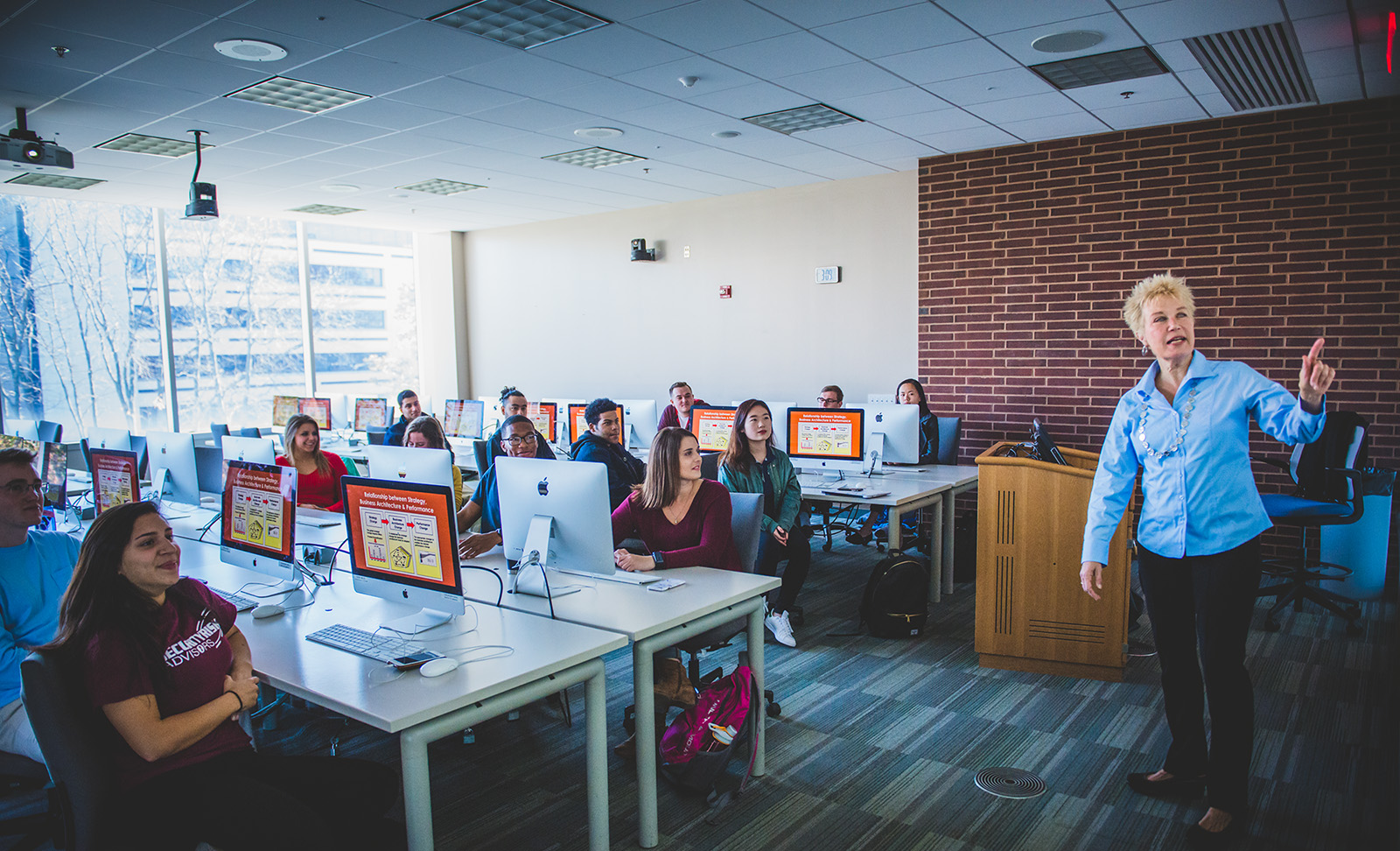 Instructor at the front of the class as students listen from their seats